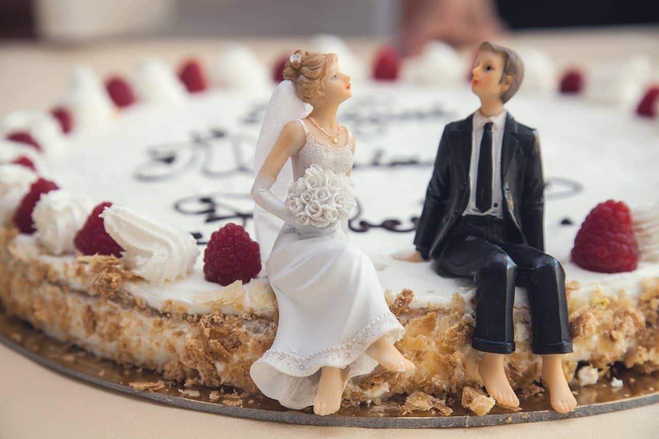 Tortenfiguren: Ein Brautpaar sitzt am Rande einer Torte.
