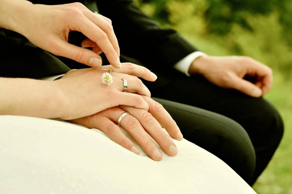 Ein Brautpaar hält Händchen.