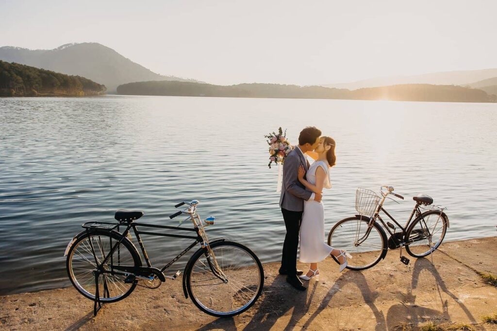 Ein Brautpaar mit Fahrrädern am Strand.